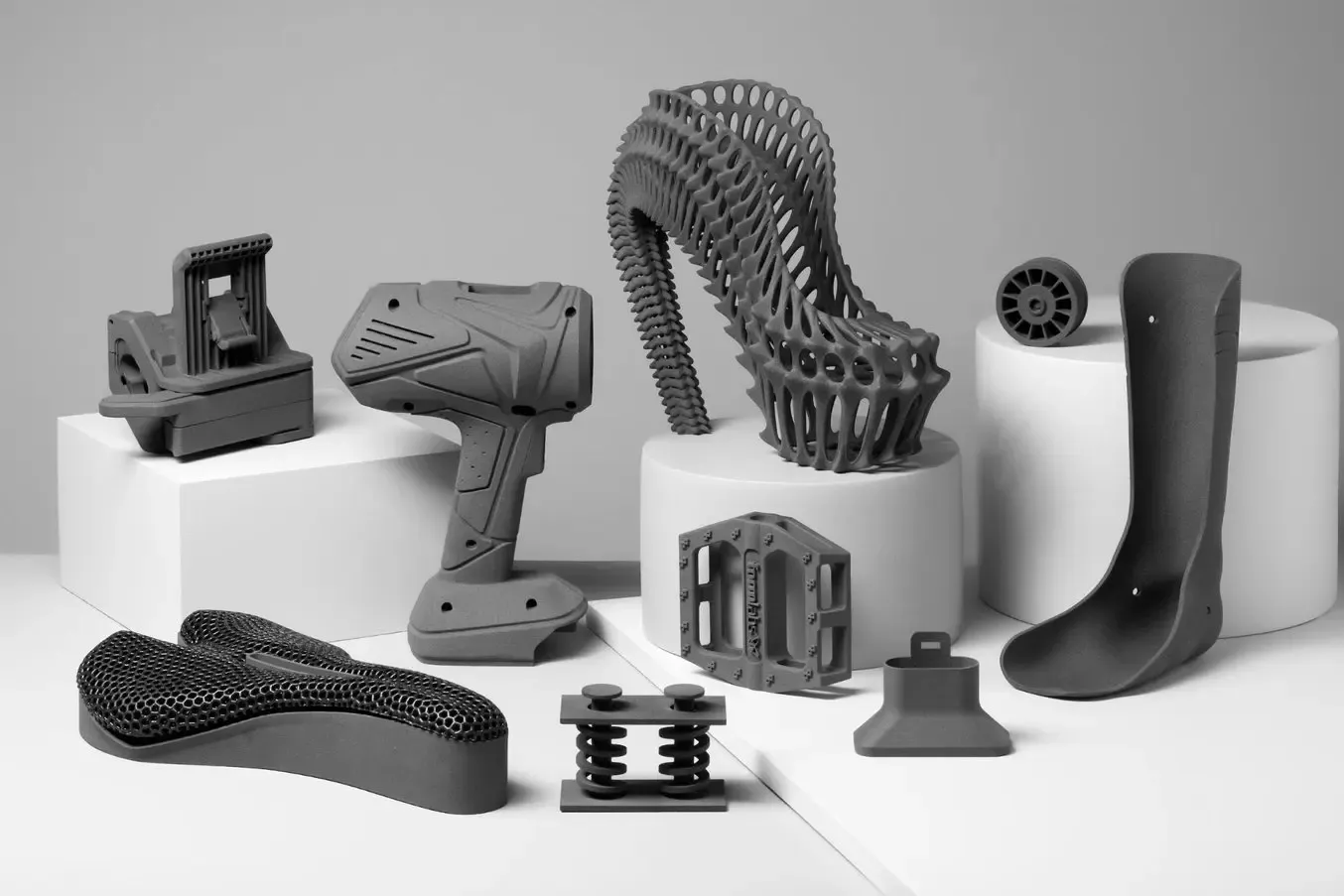 Printed engineering prototypes illustrating different manufacturing processes for engineering materials on a workbench.